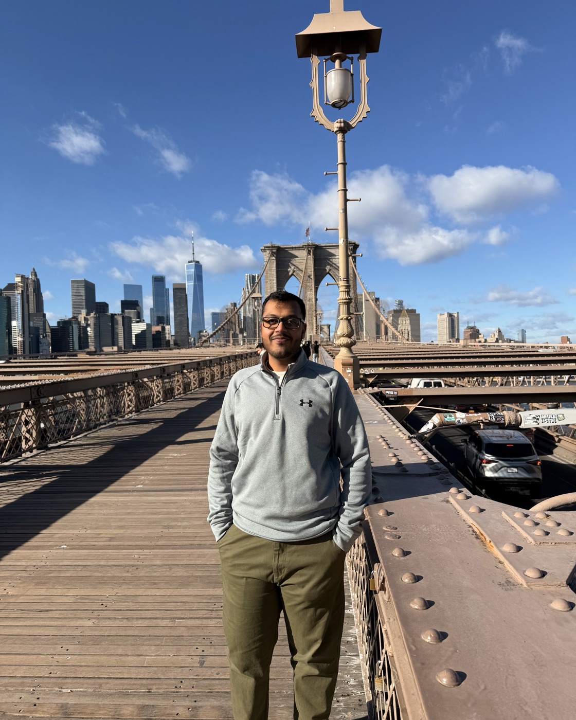 Manan Shah on the Brooklyn Bridge, Manhattan skyline behind